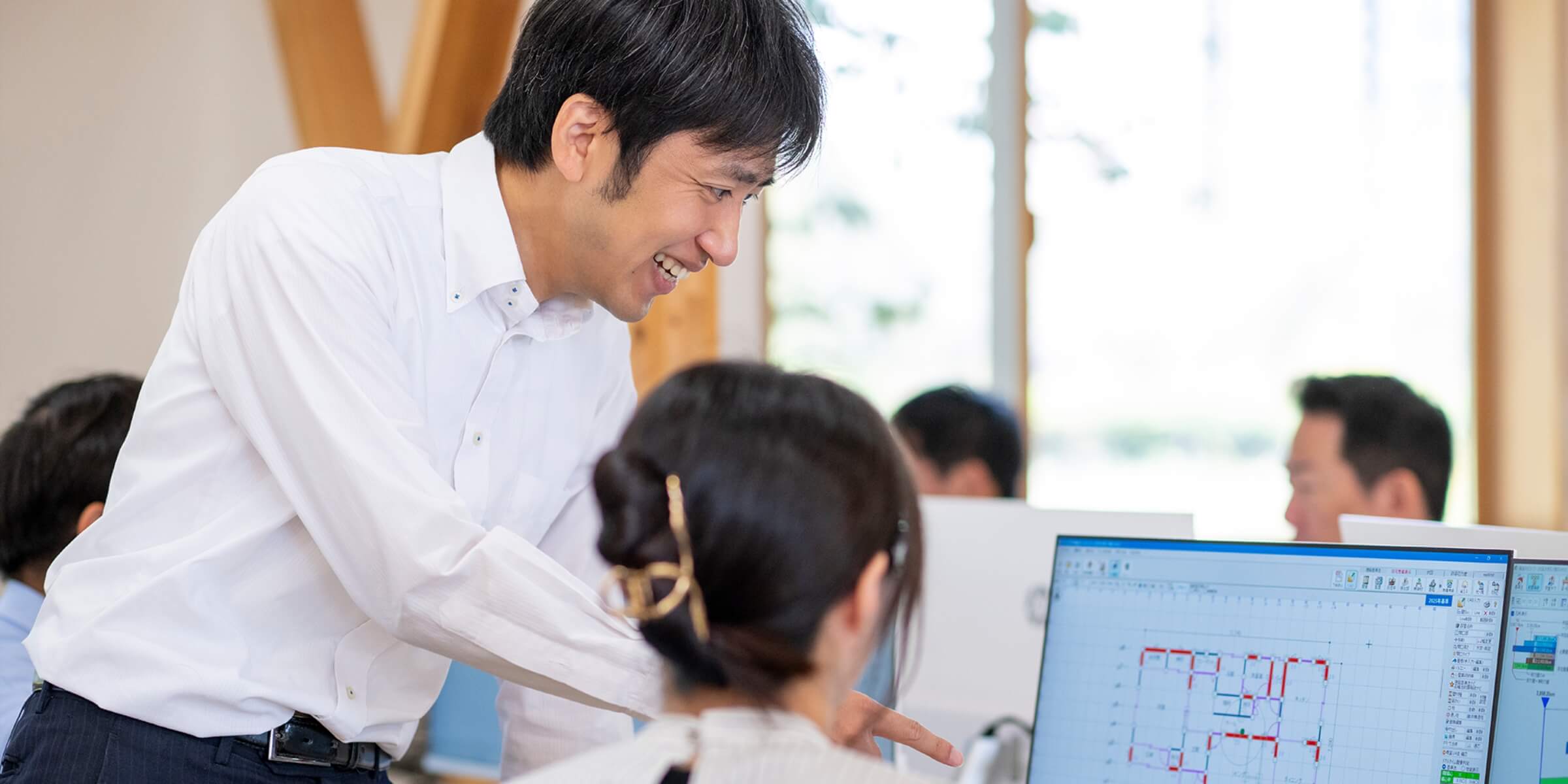 PCを指し示されながら話を聞いている様子